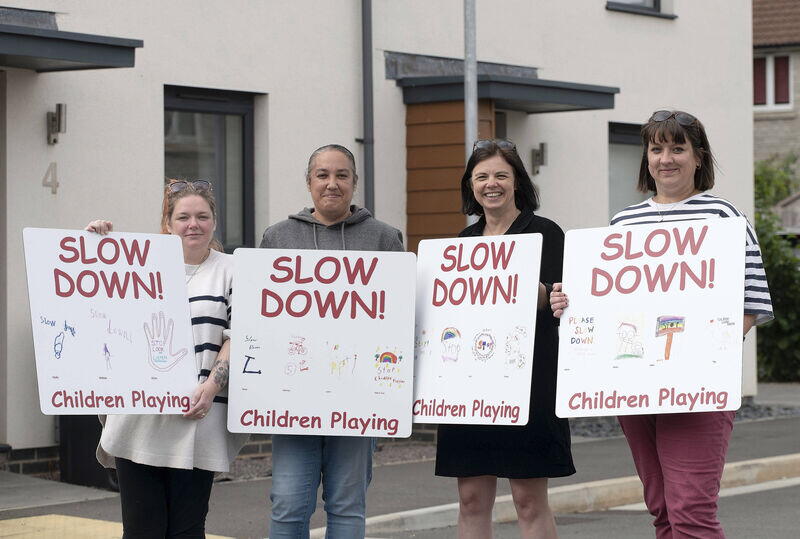 Image of LiveWest residents with our community connector and holding the 'slow down' signs.