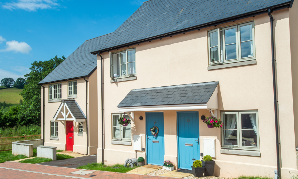 Three homes on a sunny day with bright flowers.