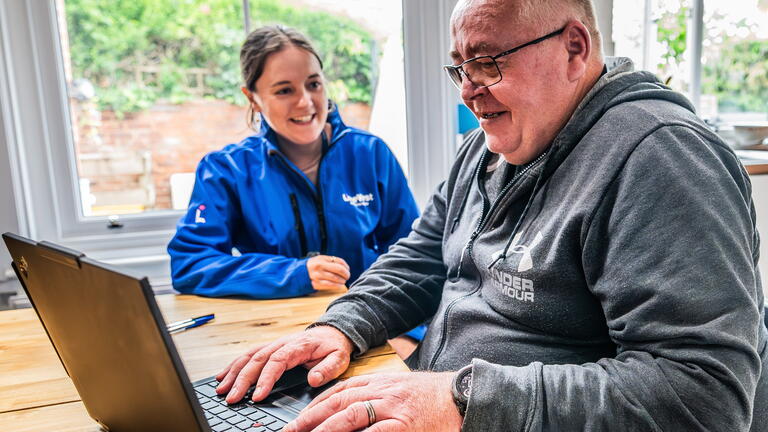 LiveWest colleague and customer using a laptop smiling