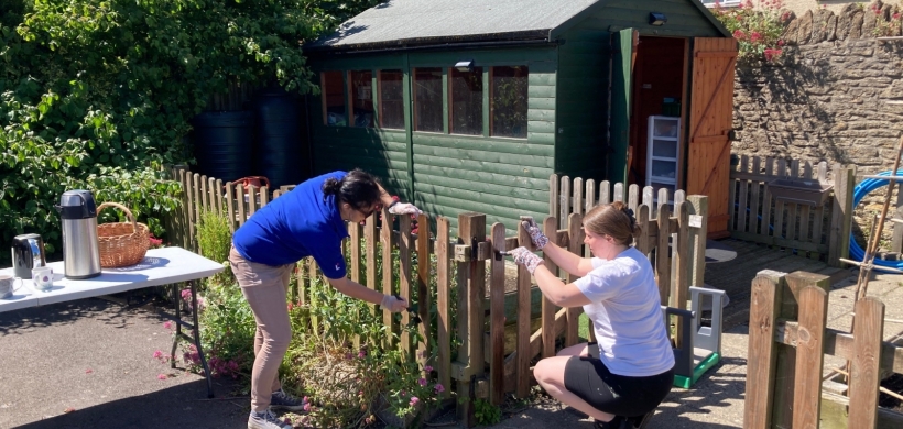 Our colleague volunteers paint a fence