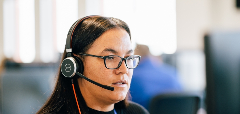 LiveWest colleague using a headset to speak on the phone. 