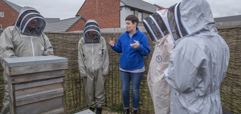 The group of volunteers at Ladden Garden Village by the beehive.