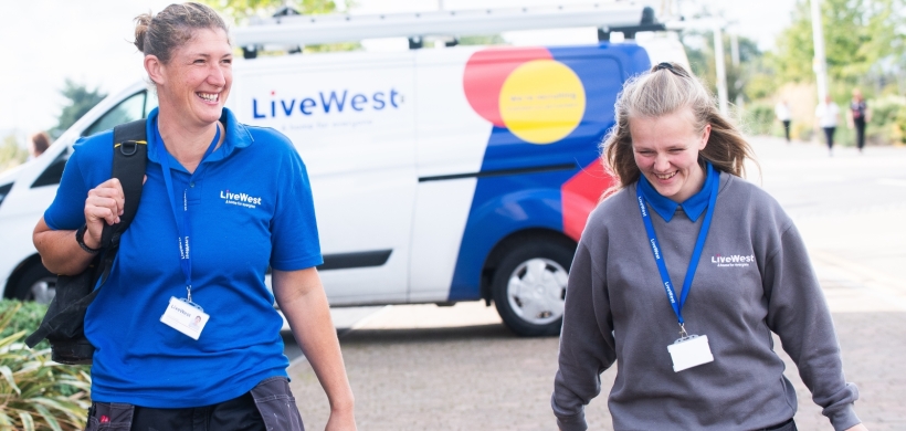 Gayle Bowden and a colleague walking with her tools from a van.