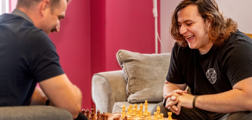 Braedon right happily playing chess with one of our support workers at the scheme.