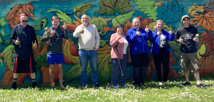 Local residents and LiveWest colleagues smiling in front of the new wall art.