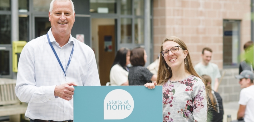 James Reseigh, LiveWest's Director of Neighbourhoods, and Suzannah Young, National Housing Federation's Policy Leader, smiling with a Starts at Home Day sign.