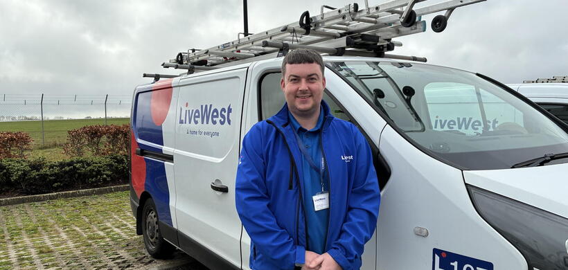 Alex in his uniform stood by his van 