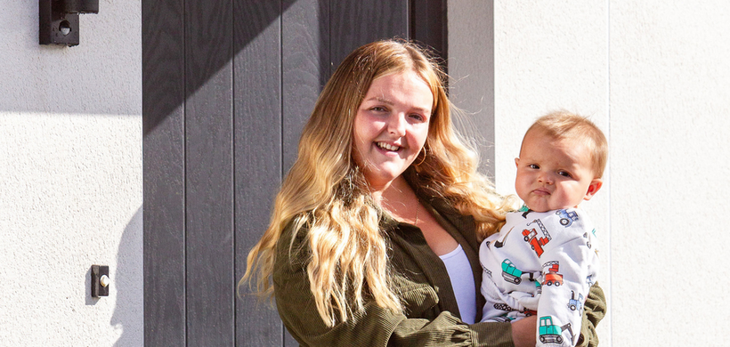 Mum and son stood outside their new home