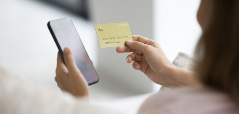 Woman online shopping with phone and credit card