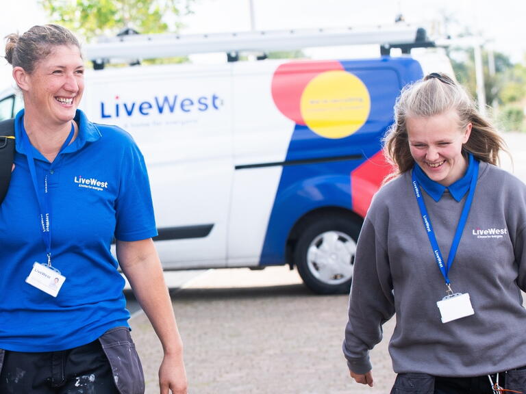Gayle Bowden and a colleague walking with her tools from a van.