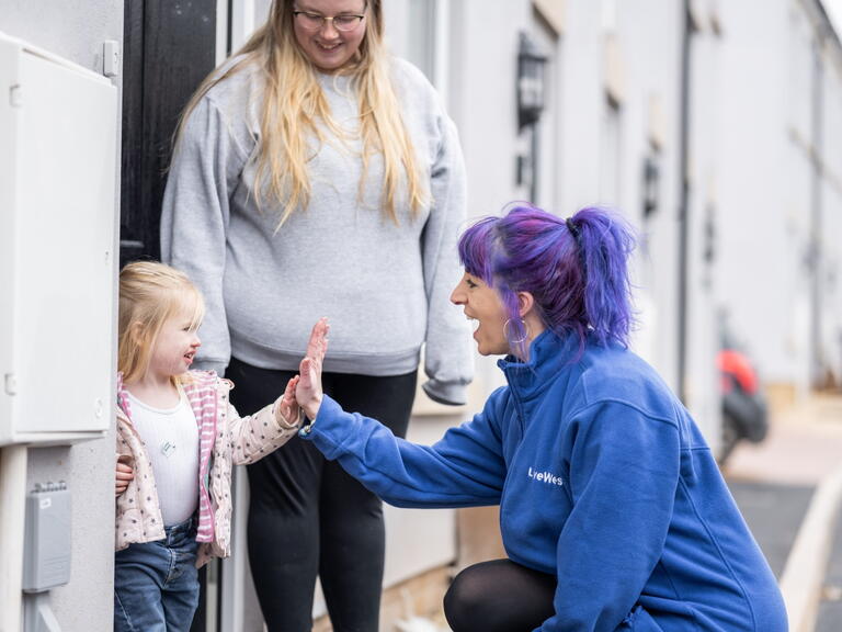 Colleague with customer and child smiling.