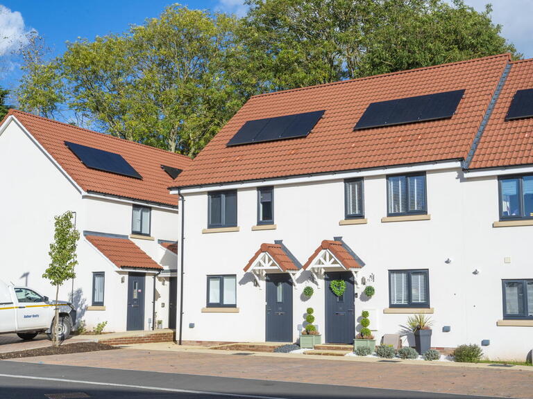 Image of white houses with solar panels on the roof.