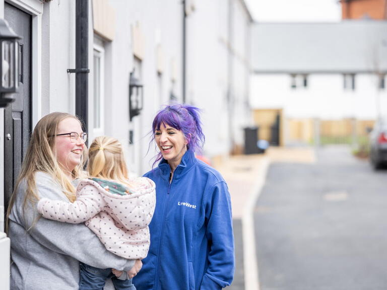 Image of a LiveWest colleague laughing with a LiveWest customer and her daughter.