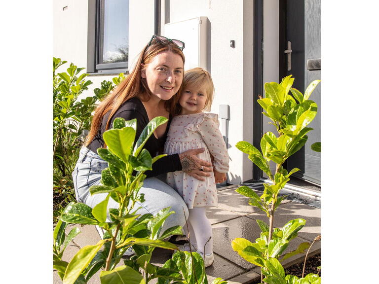 Danielle and her daughter in front of their home.