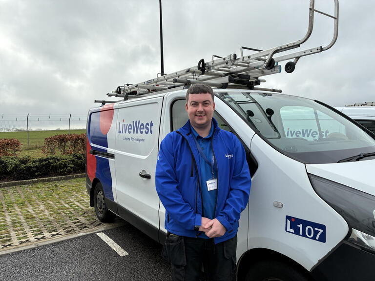 Alex in his uniform stood by his van 