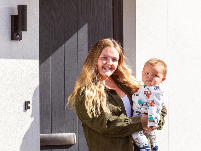 Mum and son stood outside their new home