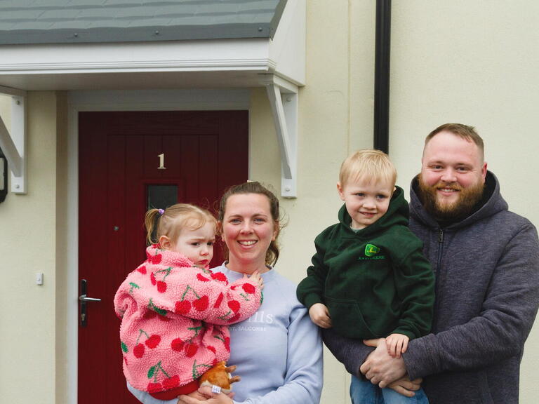 Caitlin and Chris with their son and daughter smiling at the development.