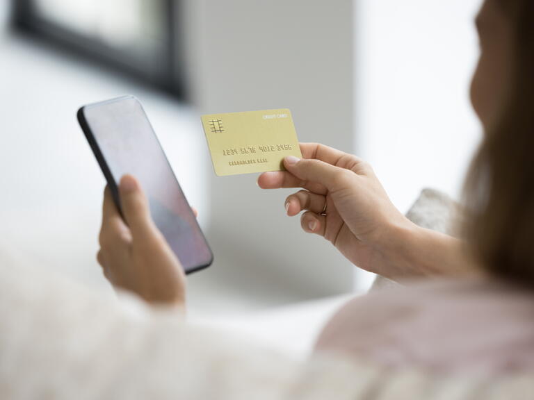 Woman online shopping with phone and credit card