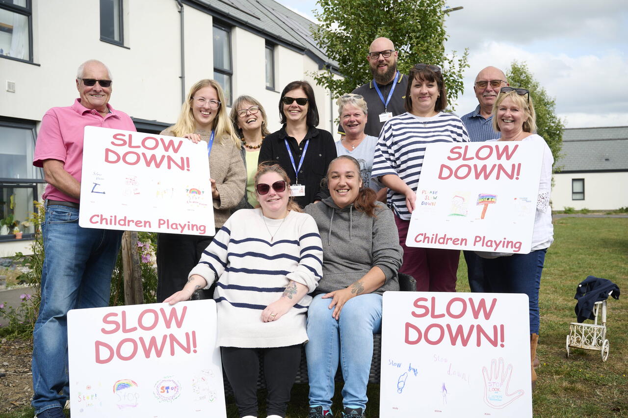 Image of Sparkford residents holding the 'slow down' signs they have made