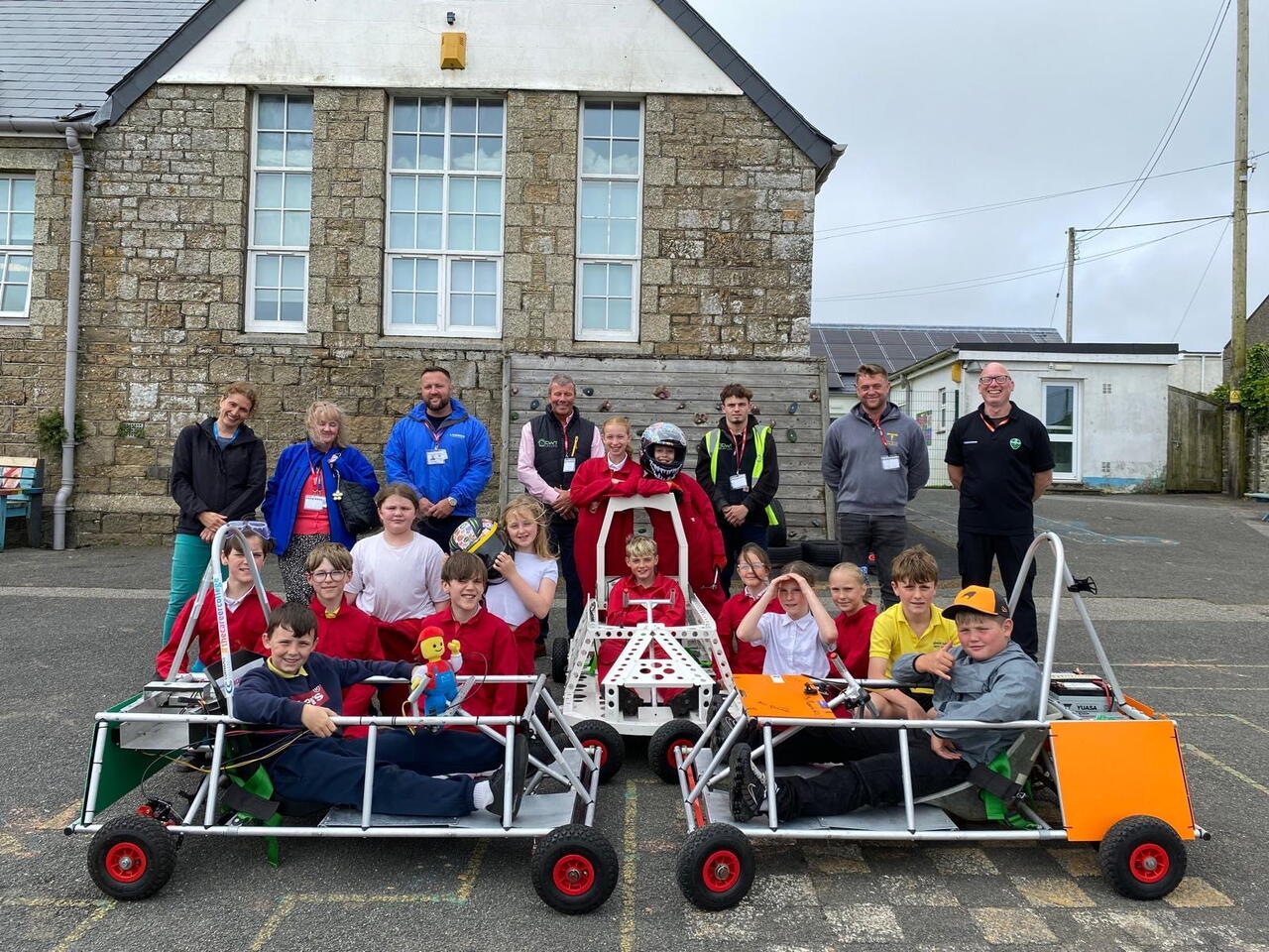 Group of people smiling in front of the Greenpower Goblin racing car