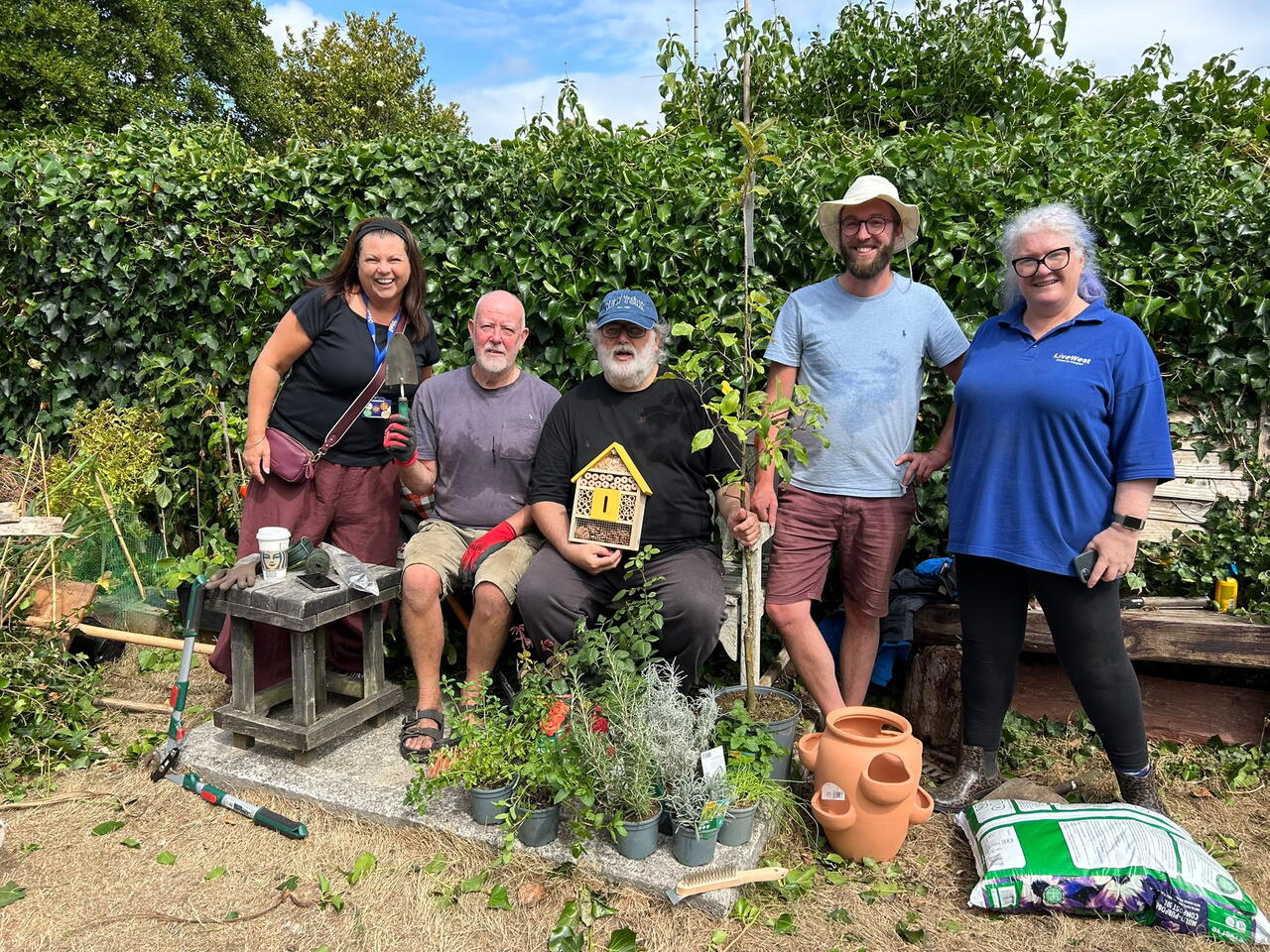 LiveWest colleagues and customers stood smiling in the communal garden