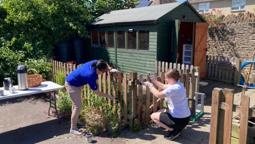 Our colleague volunteers paint a fence