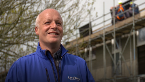 Tim Wotton in front of houses which are having solar panels installed