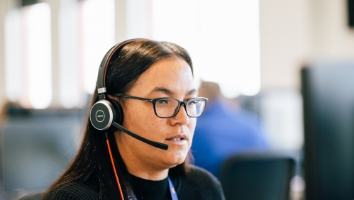 LiveWest colleague using a headset to speak on the phone. 