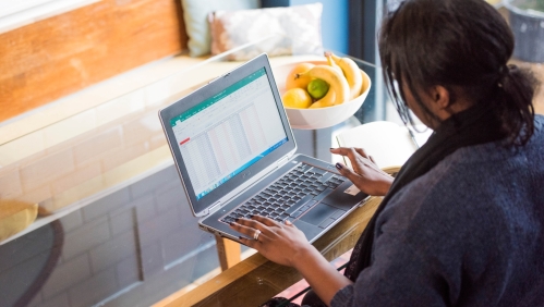 Someone using a laptop sat at a table. 