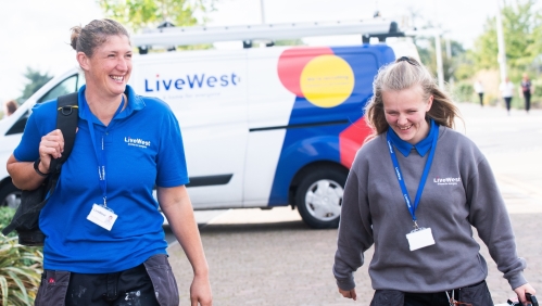 Gayle Bowden and a colleague walking with her tools from a van.