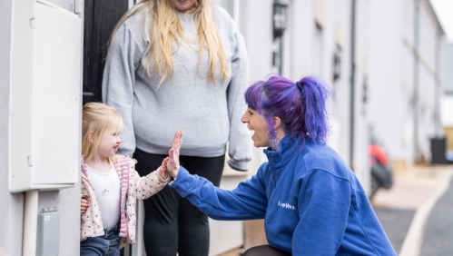 Colleague with customer and child smiling.