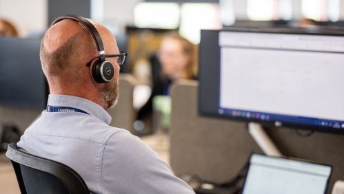 A LiveWest colleague speaking on the phone with a headset. 