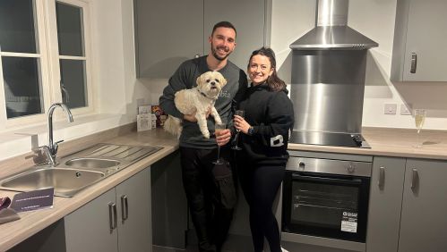 Sarah and Ashley with their dog inside their new kitchen.