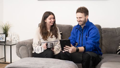 Colleague showing customer new feature on tablet