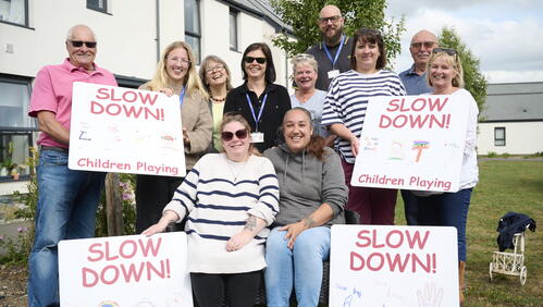 Image of Sparkford residents holding the 'slow down' signs they have made